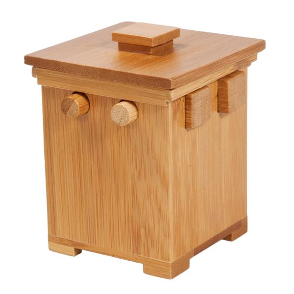 Small bamboo secret puzzle box featuring round and square wooden pegs and a flat lid with a square handle.