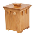 Small bamboo secret puzzle box featuring round and square wooden pegs and a flat lid with a square handle.