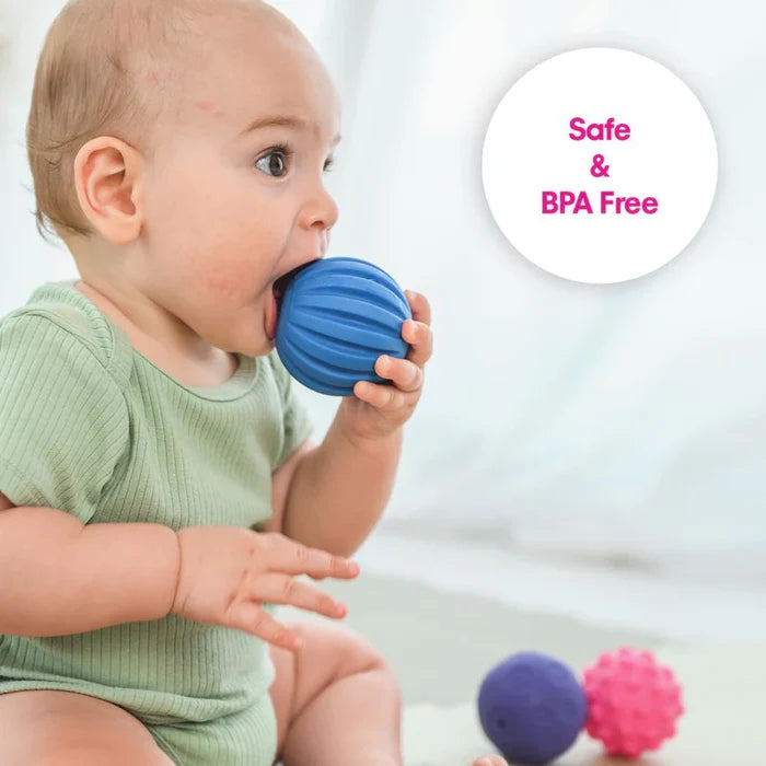 Baby chewing a blue ridged ball. Purple and pink textured balls are nearby. Text says Safe & BPA Free.