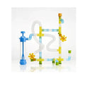 Colorful toy pipe system with translucent tubes, yellow spinning wheels, and a blue hand pump on a white background.
