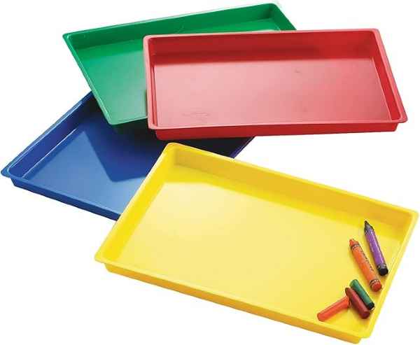 Four bright, rectangular plastic trays in green, red, blue, and yellow. A few crayons rest in the bottom yellow tray.