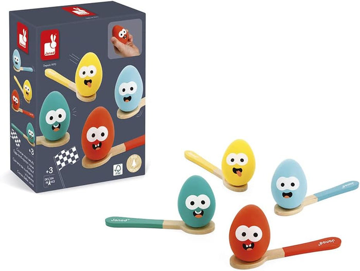 Four colorful wooden eggs with cartoon faces on matching spoons, shown alongside their Janod product packaging.