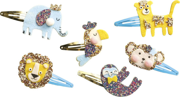 Six glittery felt animal hair clips: blue elephant, yellow leopard, lion, toucan, monkey, and colorful sloth.