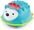 Blue dome-shaped hedgehog toy with three red spines, black facial features on a white face, and a lime green base.
