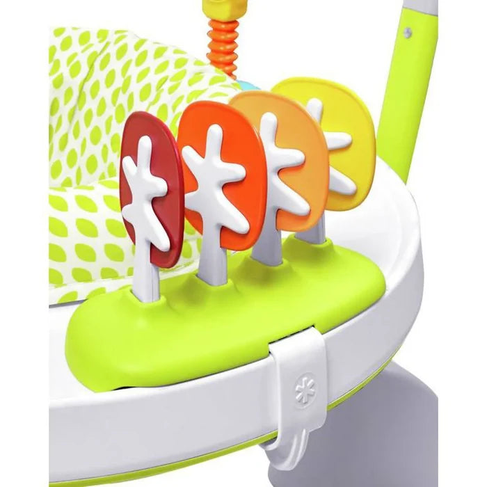 Close-up of four red, orange, and yellow tree toys on a lime green base of a white baby activity jumper.