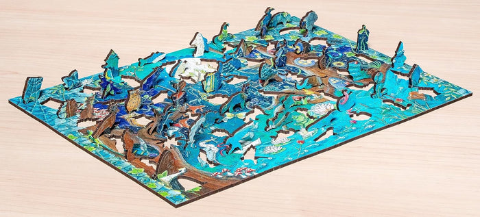 Partially assembled blue wooden puzzle of a fantasy forest with unique animal-shaped pieces standing upright.