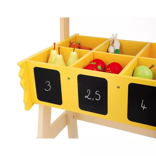 Yellow wooden toy market stall bins filled with colorful wooden fruits and chalkboard price labels.