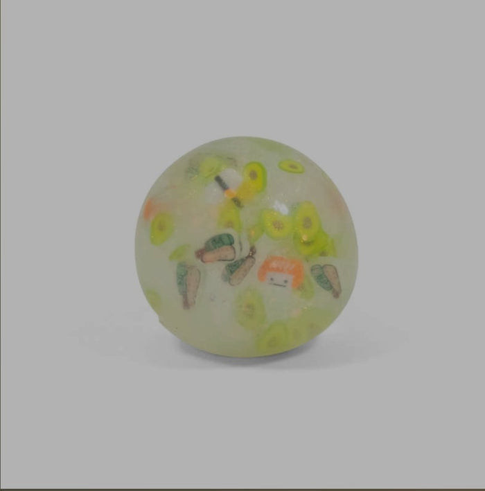 Translucent yellowish squish ball containing small colorful fast food charms like burgers and fries.