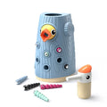 Blue woodgrain toy tree stump with yellow bird, magnetic caterpillars, and woodpecker tool on white background.
