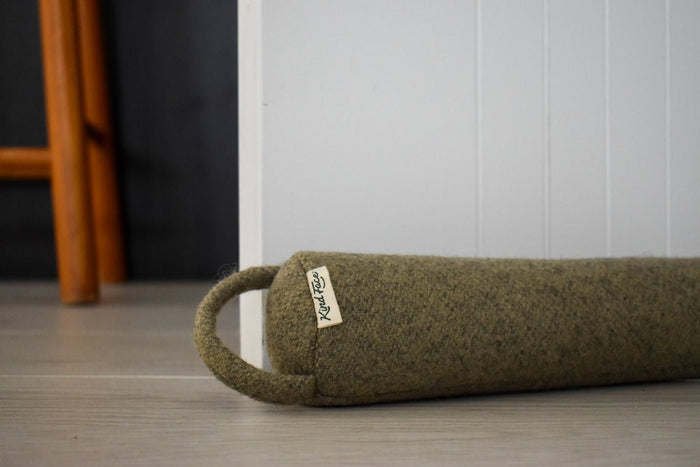 Felted NZ wool draught stopper from Do Not Disturb Sleep Company blocking a door or window to prevent drafts and heat loss.