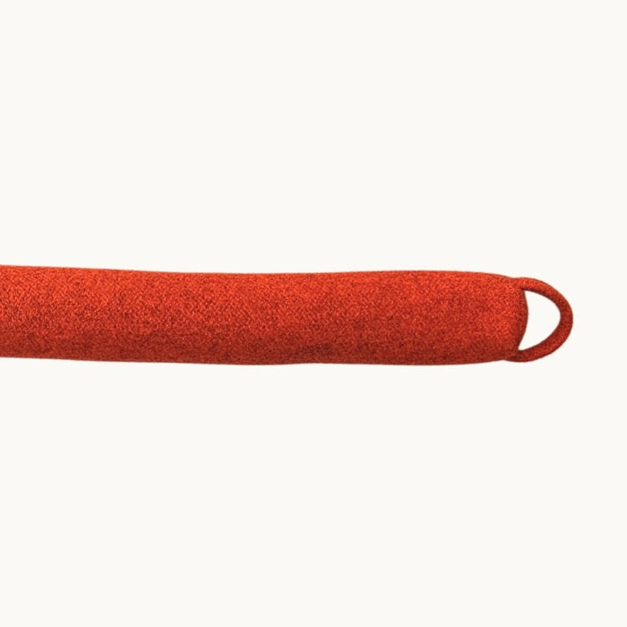 Felted NZ wool draught stopper from Do Not Disturb Sleep Company blocking a door gap to prevent drafts and heat loss.