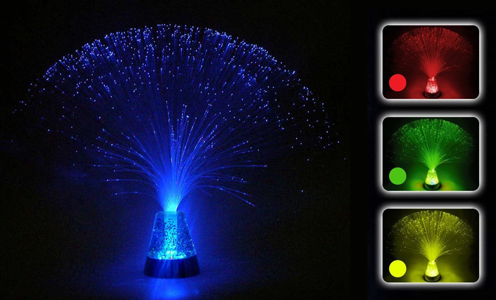 Fiber optic lamp with a glowing glitter base shown in blue, red, green, and yellow colors against a dark background.