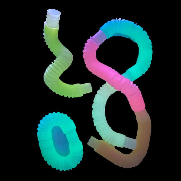 Three glowing neon accordion tubes in pink, blue, and green, bent into loops and curves on a black background.