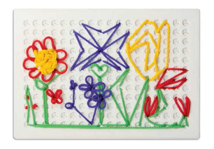 White pegboard with colorful red, yellow, blue, and green strings forming flowers, a star, and a heart.