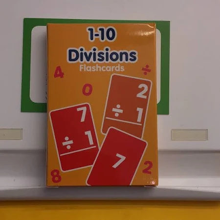 Orange box of division flashcards featuring red and orange card graphics showing math problems like 7 divided by 1.
