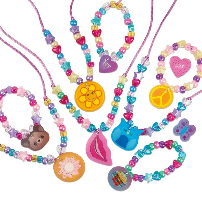 Colorful beaded necklaces and bracelets with charms including a smiley flower, blue owl, pink lips, and donut.
