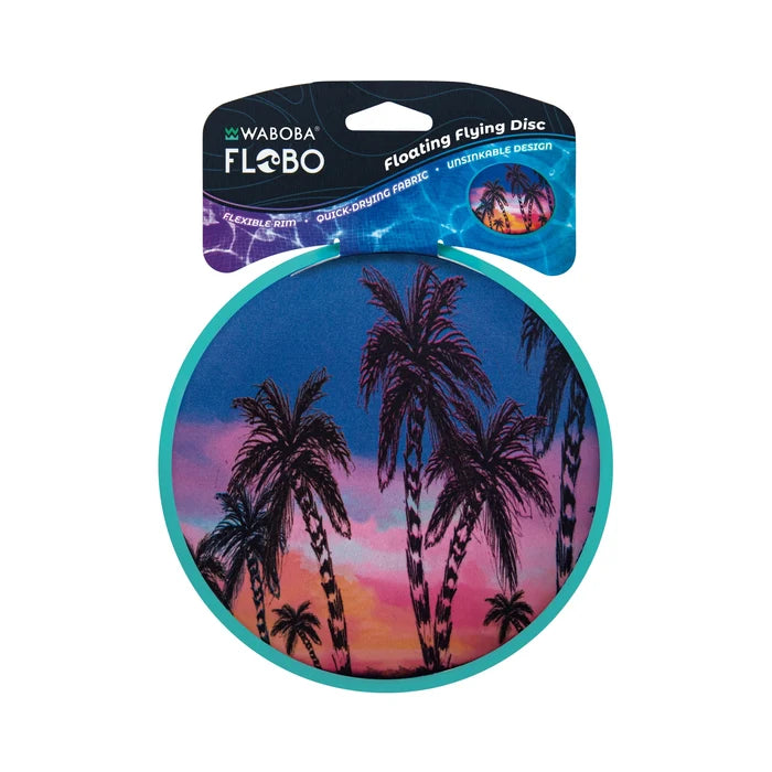 Round teal-rimmed flying disc with a tropical palm tree sunset scene, shown on its retail display card.