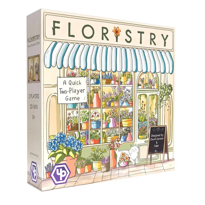 Rectangular board game box with a pastel watercolor illustration of a flower shop, striped awning, and white cat.