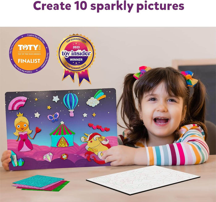 A child holds a completed sparkly foil craft of a princess and unicorn, next to colorful foil sheets and a template.