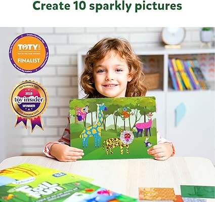 A smiling child holds a finished craft scene featuring colorful animals decorated with shimmering, patterned foil.
