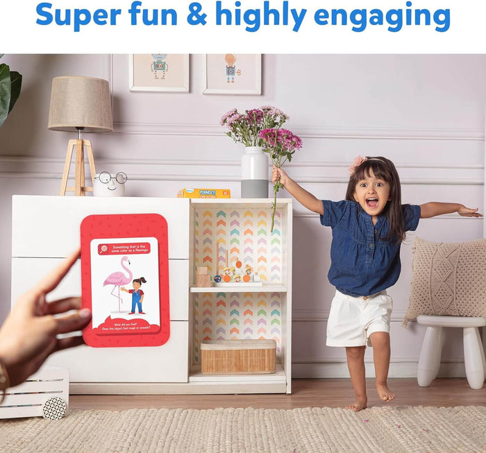 Red scavenger hunt card with a flamingo held as an excited girl finds matching pink flowers in a playroom.