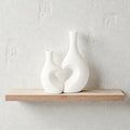 Pair of white ceramic vases with heart-shaped designs from Nest & Stem Homewares, ideal for home decor and floral arrangements.