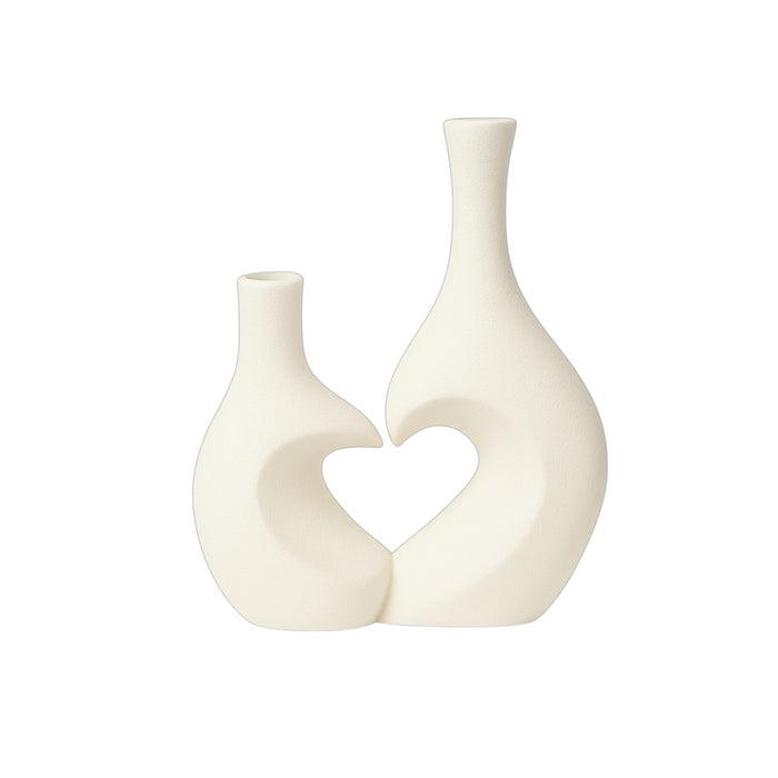 Pair of white ceramic vases with heart-shaped designs by Nest & Stem Homewares, perfect for modern home decor.