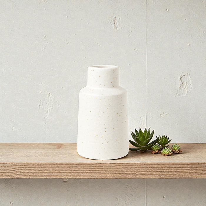 Small white ceramic vase with speckle pattern by Nest & Stem Homewares, ideal for holding flowers or decorative arrangements.
