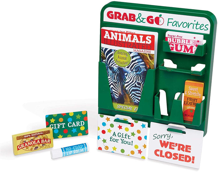 Green toy display rack with miniature magazine, bubble gum, granola bar, lip balm, gift cards, and closed sign.