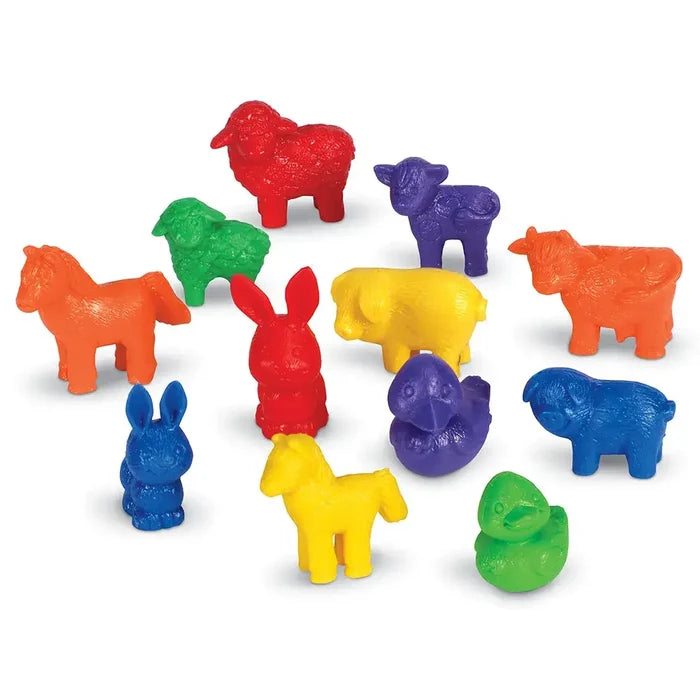 Small plastic farm animal figurines in vibrant red, orange, yellow, green, blue, and purple on a white background.