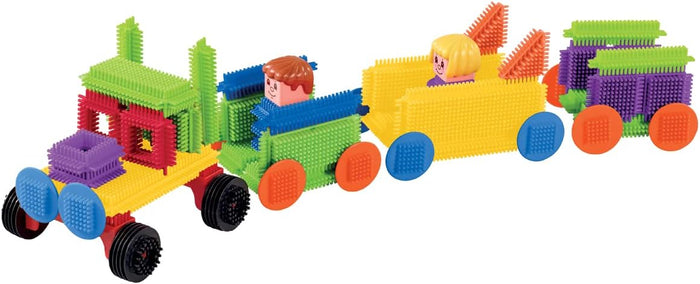 Colorful toy vehicle built from textured bristle blocks in bright colors, with two small figures and plastic wheels.