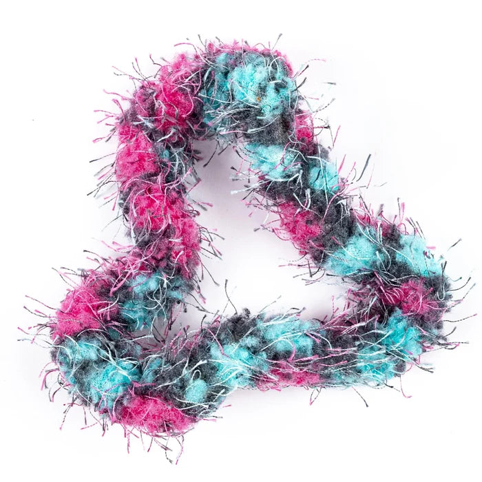 Pink, turquoise, and grey fuzzy textured fidget toy arranged in a heart-shaped loop.