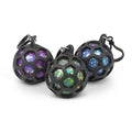 Three squish balls in black honeycomb cages with purple, green, and blue glitter interiors and attached key clips.
