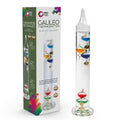 Tall glass Galileo thermometer with colorful floating bulbs next to its white and green box with rainbow graphics.