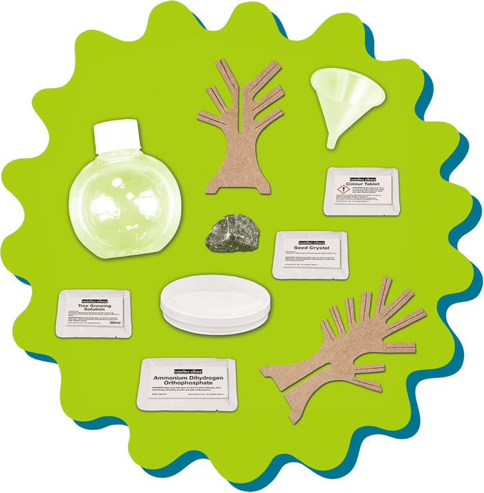 Science kit contents: chemical packets, cardboard tree cutouts, a clear round bottle, small tray, rock, and white funnel.