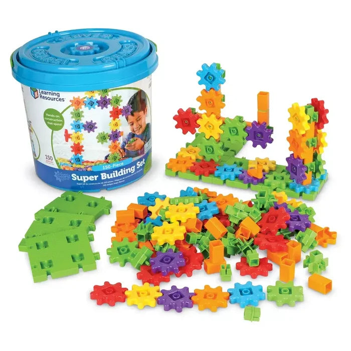 Blue storage bucket next to colorful plastic gear pieces, green base plates, and assembled structures.