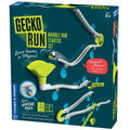 Vertical marble run toy box showing white tracks and lime green funnels attached to a wall by blue adhesive pads.