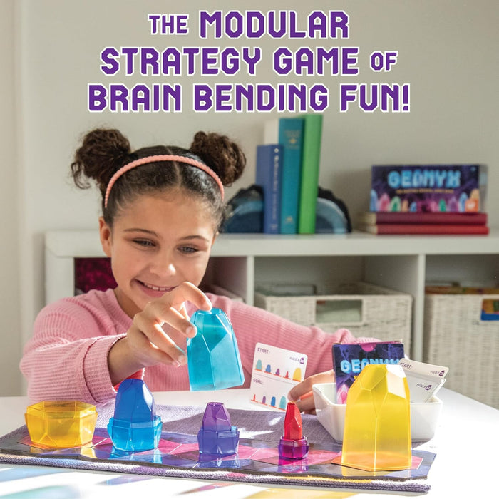 A child plays with colorful translucent gem-shaped pieces on a game board with puzzle cards.