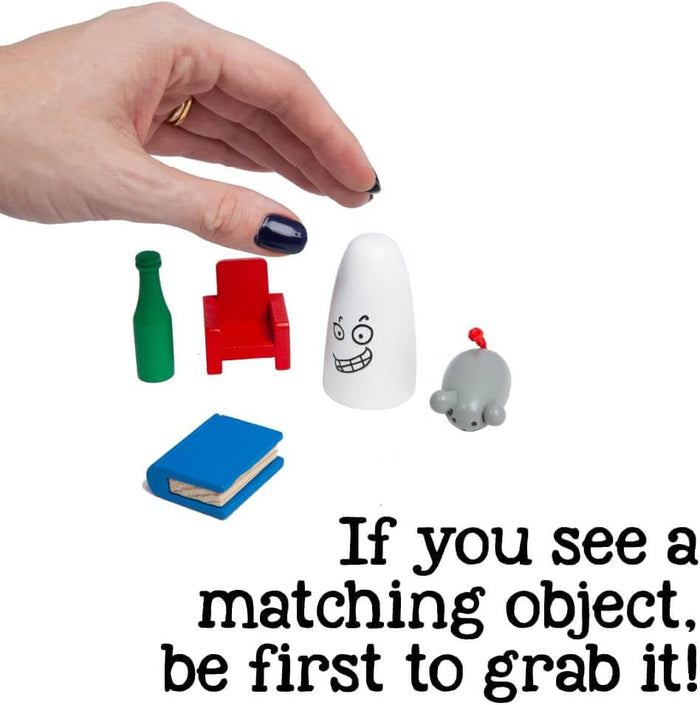 Hand reaching for a white wooden ghost next to a red chair, green bottle, blue book, and grey mouse game pieces.