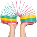Hands holding a large, arched rainbow spring toy with bright pink, yellow, green, and blue plastic coils.