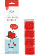 Red and white Glo Pals packaging next to a stack of four red, translucent water-activated cubes with smiling faces.