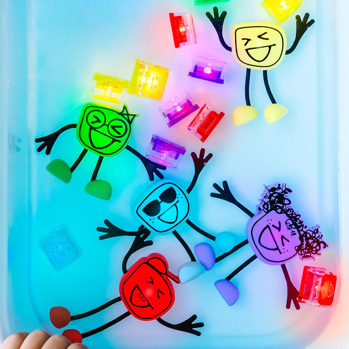 Five colorful character toys and several glowing cubes floating in a tray of water with vibrant light.