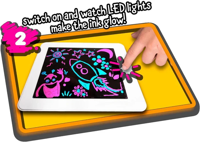 Hand touching a white drawing pad with glowing neon pink and blue sketches of a rocket and alien on a black screen.