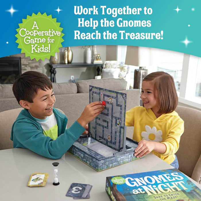 Two children play a vertical maze game using magnetic gnomes, a sand timer, and cards beside the colorful game box.
