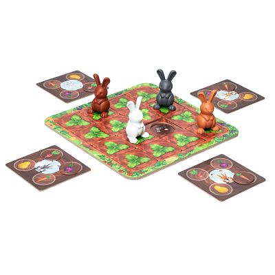 Four colorful plastic bunny figures on a garden-themed grid game board with four square vegetable cards.