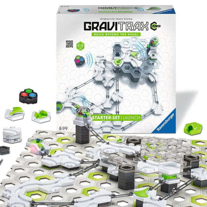 Product box and built marble run with white, green, and grey hexagonal pieces, metal rails, and silver marbles.