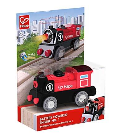 Red and black toy train engine with number 1, displayed in its retail packaging with a city-themed background.