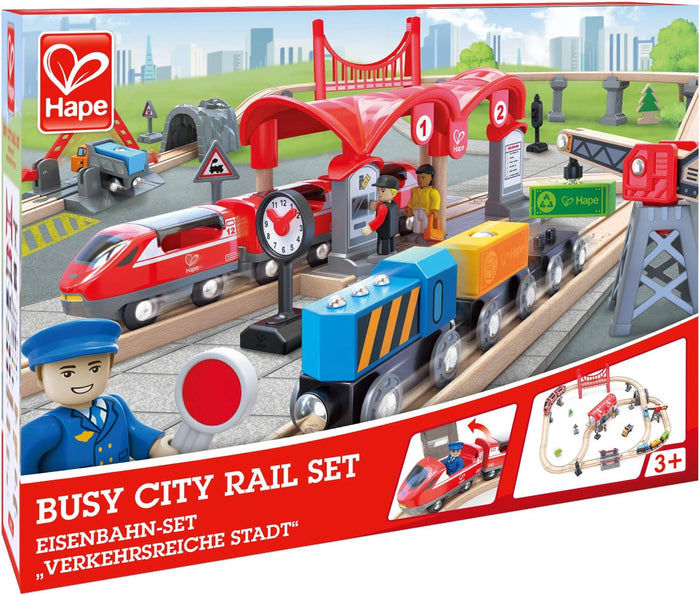 Wooden toy train set box featuring red and blue trains, a station, bridge, and crane on a track layout.