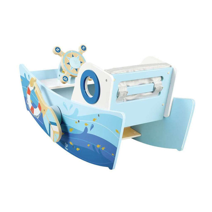 Light blue wooden rocking boat toy with fish illustrations, a ship's wheel, and a grey cushioned bench seat.