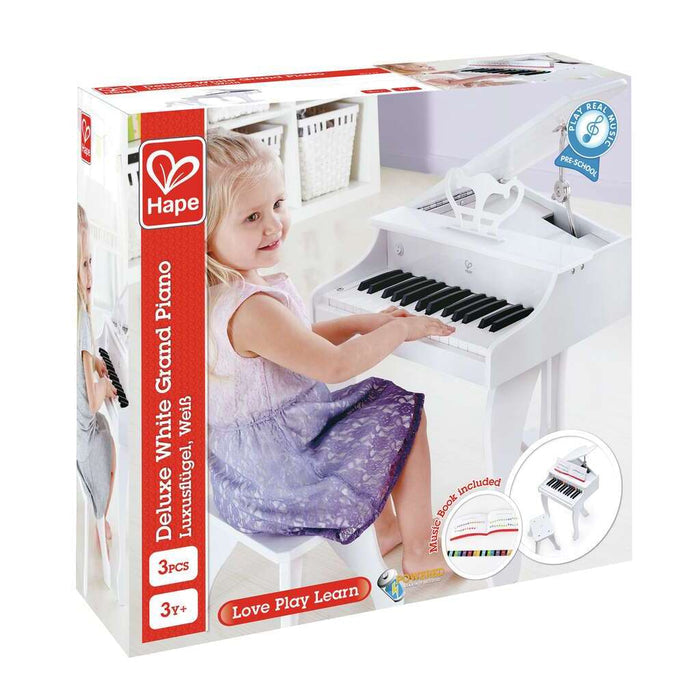 Packaging for a white toy grand piano with stool. Image shows a girl playing the 30-key instrument with music book.